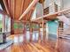 Spacious open-concept interior with log walls, wood floors, vaulted ceilings, and an open staircase at 1000 Lodgepole Dr, Evergreen, CO 80439