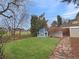 Backyard features a shed, lush lawn, garden beds, and a stone pathway at 6501 Welch Ct, Arvada, CO 80004