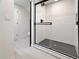 Bathroom with glass-enclosed shower featuring a black showerhead and black hexagon-shaped floor at 6501 Welch Ct, Arvada, CO 80004