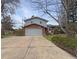 Two story house with a large gray garage door, brick facade, and concrete driveway at 6501 Welch Ct, Arvada, CO 80004