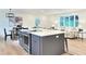 Bright and airy kitchen featuring a large island, stainless steel appliances, and adjacent dining and living areas at 6501 Welch Ct, Arvada, CO 80004