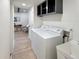 Laundry room featuring a utility sink, overhead cabinets, and a front-load washer and dryer at 6501 Welch Ct, Arvada, CO 80004