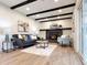 Relaxing living room featuring a cozy fireplace, comfortable seating, and sleek wooden beams for added character and style at 6501 Welch Ct, Arvada, CO 80004