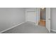 Bedroom boasts gray carpet, a closet, and an entry door to the hallway at 6905 Mariposa St # C, Denver, CO 80221