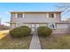 Two-story home featuring stone accents, tidy landscaping, and a well-maintained walkway at 6905 Mariposa St # C, Denver, CO 80221