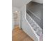 Hallway featuring a staircase with carpet runner and a view of the bathroom at 6905 Mariposa St # C, Denver, CO 80221