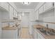 Functional kitchen featuring tiled backsplash, white cabinets, and ample counter space at 6905 Mariposa St # C, Denver, CO 80221