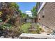 View of the backyard featuring a garden, wooden fence, grass and trees at 1584 S Fraser Way, Aurora, CO 80012