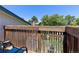 Outdoor deck with wooden railing overlooks lush greenery and a clear blue sky at 1584 S Fraser Way, Aurora, CO 80012