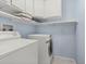 Dedicated laundry area with washer, dryer, and ample shelf storage at 1584 S Fraser Way, Aurora, CO 80012