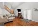 Bright living room featuring a cozy fireplace, wood floors, and access to the backyard at 1584 S Fraser Way, Aurora, CO 80012