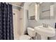 Bathroom features a white tiled stand up shower with an anchor-themed curtain and white vanity at 6592 S Cody Way, Littleton, CO 80123