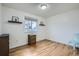 Bright bedroom featuring hardwood floors, a window, and floating shelves at 6592 S Cody Way, Littleton, CO 80123