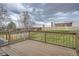 A wooden deck overlooks the well-maintained backyard featuring a green lawn and a wooden fence for privacy at 6592 S Cody Way, Littleton, CO 80123
