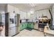 Bright kitchen boasts white and green cabinets, stainless steel appliances, and ample counter space at 6592 S Cody Way, Littleton, CO 80123