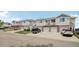 View of the exterior of townhomes with a brick base and siding, featuring garages and driveway parking at 10129 W 55Th Dr # 3, Arvada, CO 80002