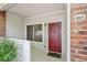 Condo front door with a red door, sidelight window, and outdoor lighting at 10129 W 55Th Dr # 3, Arvada, CO 80002