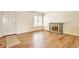 Inviting living room with wood flooring, a cozy fireplace, and ample natural light from the window at 4182 S Joplin St, Aurora, CO 80013