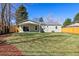 Well-maintained backyard featuring a spacious lawn, wood fence, and covered patio at 1430 S Glencoe St, Denver, CO 80222