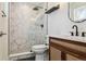 Bathroom featuring walk-in shower, dark fixtures, decorative tile, and a modern sink at 1430 S Glencoe St, Denver, CO 80222