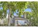 Rear exterior of house with a stone chimney and a patio with chairs and lush greenery at 1540 W Briarwood Ave, Littleton, CO 80120