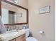 Half bathroom featuring a granite-topped vanity, a decorative mirror, and a neutral color palette at 1540 W Briarwood Ave, Littleton, CO 80120