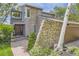 Exterior of a two-story home with stone and wood siding and a brick walkway at 1540 W Briarwood Ave, Littleton, CO 80120