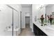 Modern bathroom featuring a double sink vanity, tiled floors, and a glass-enclosed shower at 15501 E 112Th Ave # 6F, Commerce City, CO 80022