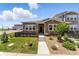 Charming home featuring a stone facade, well-maintained lawn, and inviting entrance in a vibrant community at 15501 E 112Th Ave # 6F, Commerce City, CO 80022