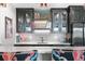 Contemporary bar area with stylish lighting, sleek countertops, and ample glassware storage at 8625 Eagle Moon Way, Parker, CO 80134