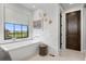 Modern bathroom featuring a soaking tub, marble accents, and natural light from the window at 8625 Eagle Moon Way, Parker, CO 80134