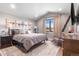Comfortable bedroom with neutral tones, textured bedding, and decorative airplane art at 8625 Eagle Moon Way, Parker, CO 80134