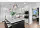 A modern kitchen featuring white cabinetry, a large marble island, and stainless steel appliances at 8625 Eagle Moon Way, Parker, CO 80134