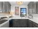 Well-lit laundry room with a sink, a window, upper cabinets, and a front-load washing machine at 8625 Eagle Moon Way, Parker, CO 80134