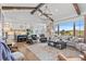 Open-concept living room with wood beams, chandelier, stone fireplace, and a spacious seating area at 8625 Eagle Moon Way, Parker, CO 80134