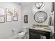 Modern powder room with decorative wall art, round mirror and dark wood vanity at 8625 Eagle Moon Way, Parker, CO 80134