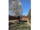 Fenced backyard featuring a tree with white blooms, landscaping and lush green grass at 4483 S Fundy St, Centennial, CO 80015