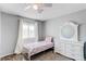 Bright bedroom with white ceiling fan, large window with white curtains, white dresser and mirror at 4483 S Fundy St, Centennial, CO 80015