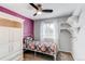 Cozy bedroom features a ceiling fan, bright window with decorative white curtains and built-in wall shelving at 4483 S Fundy St, Centennial, CO 80015