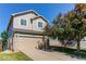 Inviting two-story home with a well-manicured lawn, blossoming tree and attached garage at 4483 S Fundy St, Centennial, CO 80015