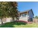 Charming home exterior featuring lush landscaping, lawn and a blossoming tree at 4483 S Fundy St, Centennial, CO 80015