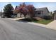 A pleasant home exterior with a mature, blossoming tree in a well-kept yard at 4483 S Fundy St, Centennial, CO 80015