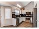 Well-lit kitchen features stainless steel appliances, dark countertops, and white cabinets at 4483 S Fundy St, Centennial, CO 80015