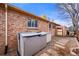 Backyard view of brick home with window and storage structures, surrounded by stone walkway and gravel at 2576 Krameria St, Denver, CO 80207