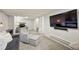 Basement seating area featuring a large TV, a comfortable chair and ottoman, and neutral carpet at 2576 Krameria St, Denver, CO 80207