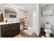 Well-lit bathroom with marble countertop, dark vanity, decorative shower curtain, and tiled floors at 2576 Krameria St, Denver, CO 80207