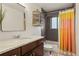 Bathroom featuring a vanity with marble countertop, decorative shelving, and a shower-tub combo at 2576 Krameria St, Denver, CO 80207