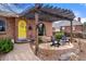 Inviting front porch with brick detail, a yellow door with wreath, and a covered seating area with stylish chairs at 2576 Krameria St, Denver, CO 80207
