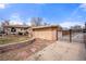 Separate garage structure adjacent to the brick home with a gated driveway at 2576 Krameria St, Denver, CO 80207