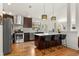 Bright, modern kitchen featuring stainless steel appliances, a kitchen island and stylish pendant lighting at 2576 Krameria St, Denver, CO 80207